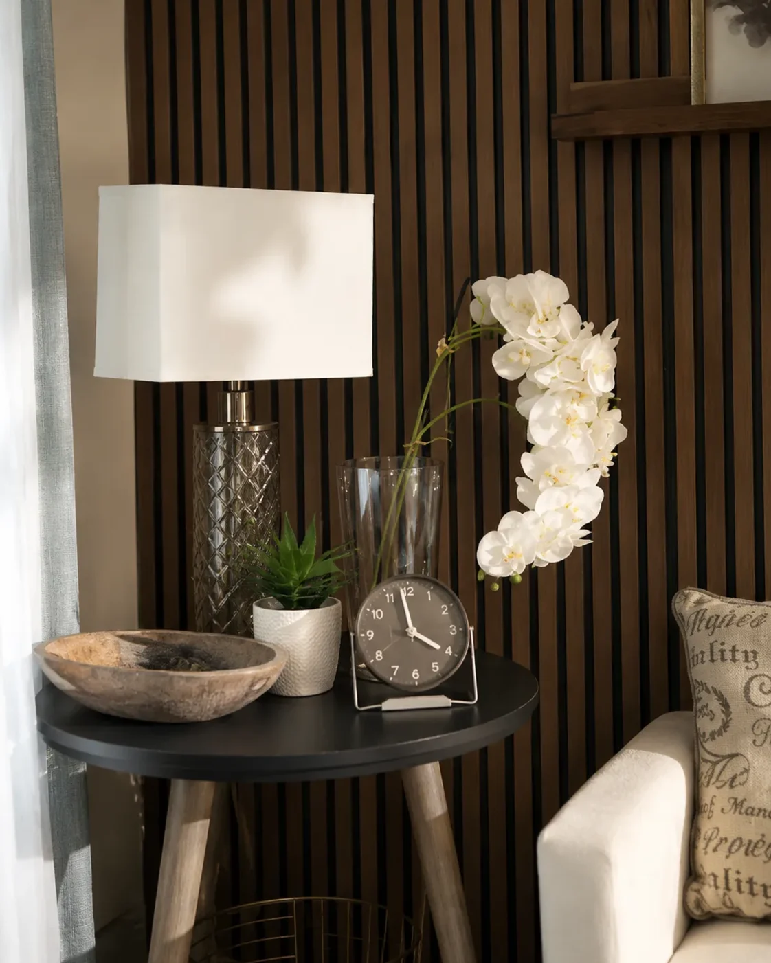 Side table with a lamp, orchids and a clock in the Despertares Counseling office in Phoenix